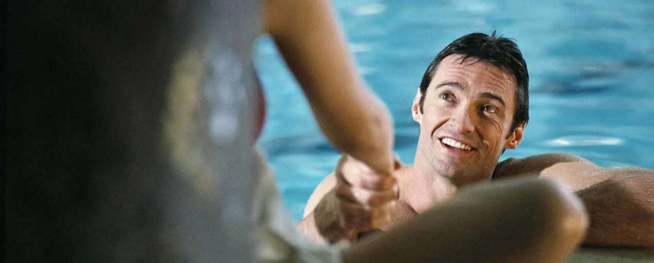 Here's an alt tag for the image: Smiling man in pool, handshakes.