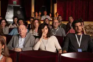 Here's an alt tag for the image: `Audience watching a performance in a theater.`