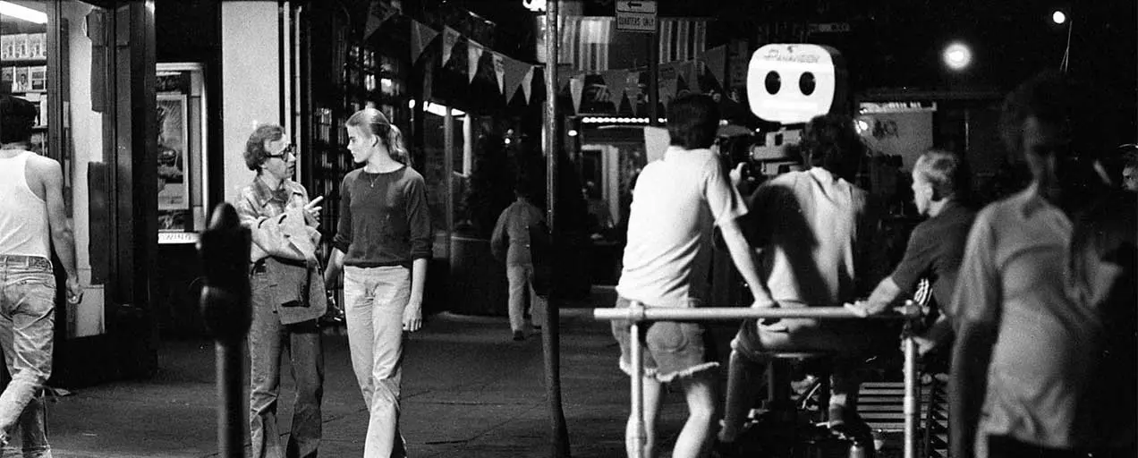 Black and white film crew on city street.