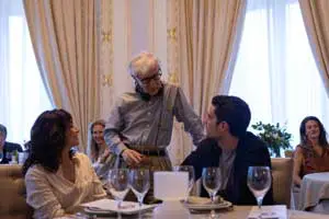 Here's an alt tag for the image: Woody Allen with actors at a restaurant.