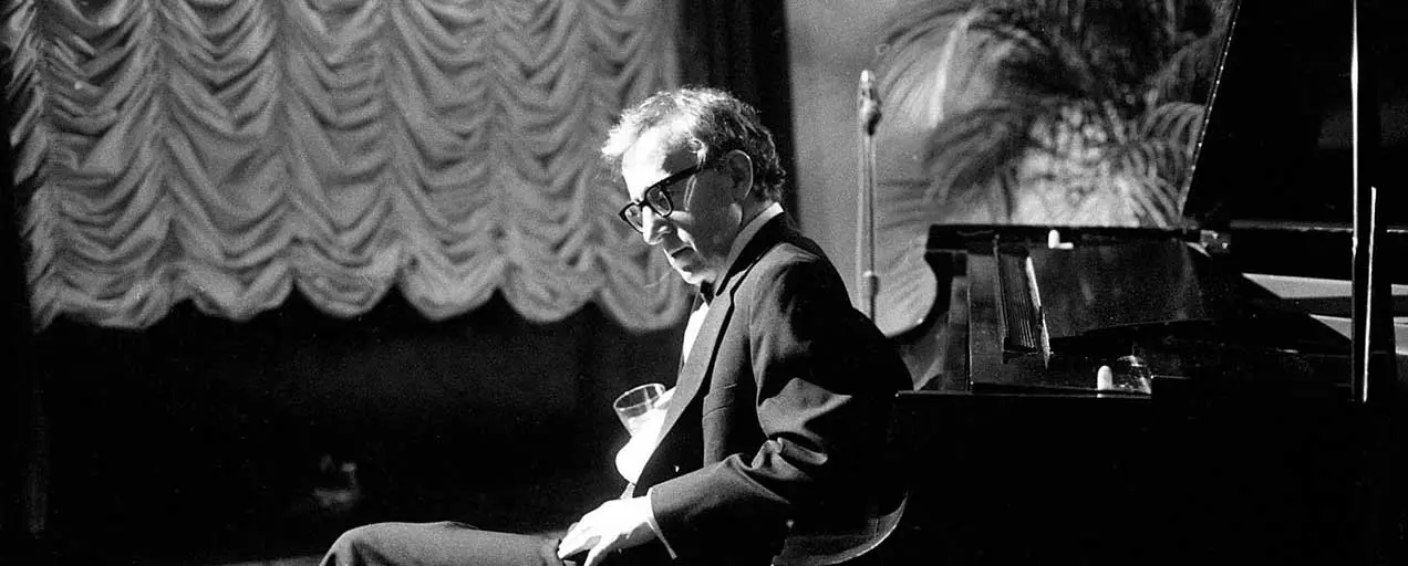 Black and white photo of Leonard Bernstein at a piano.