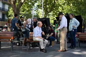 Here's a short alt tag for the image: `Film crew filming scene in park`