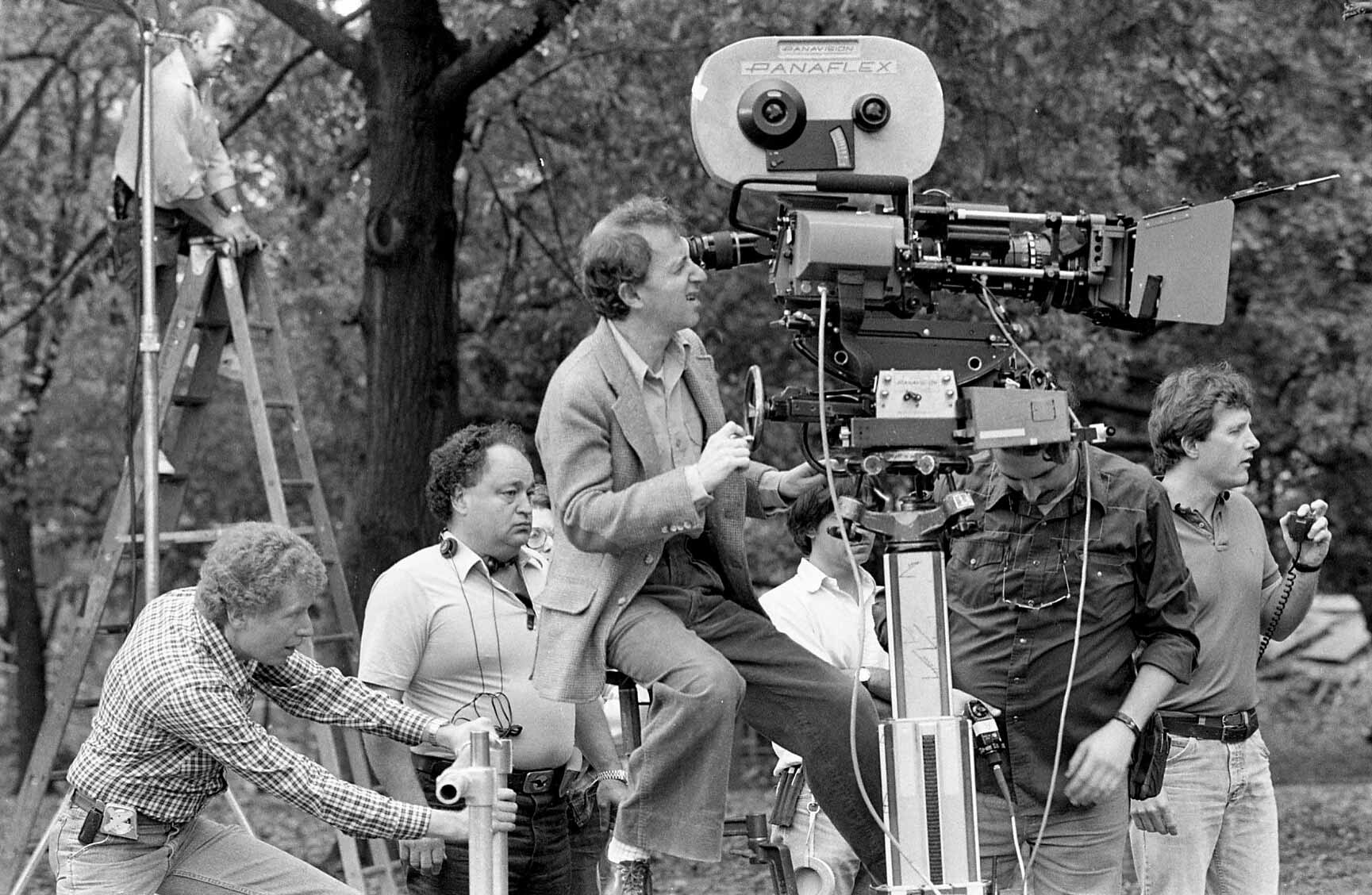 Film crew operating camera equipment outdoors.